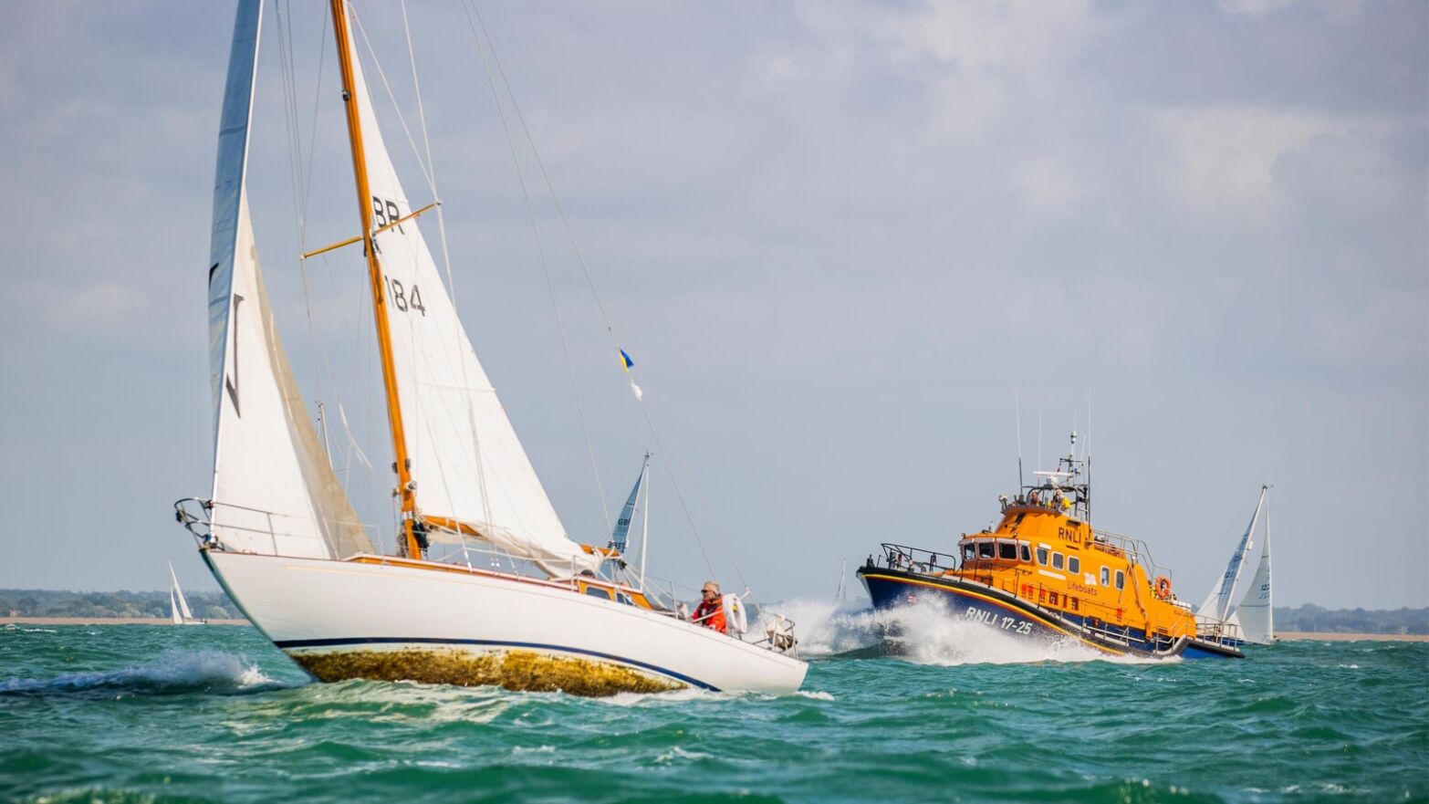 A yacht with an RNLI lifeboat alongside