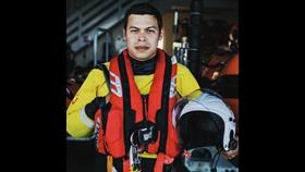 Josh Owens, Portsmouth Lifeboat crew, in full kit, smiling at the camera