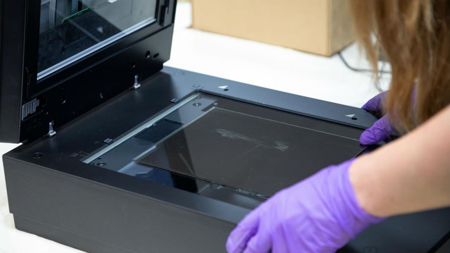 Colour image of glass plate negative being scanned