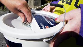 Money being donated into a collection box