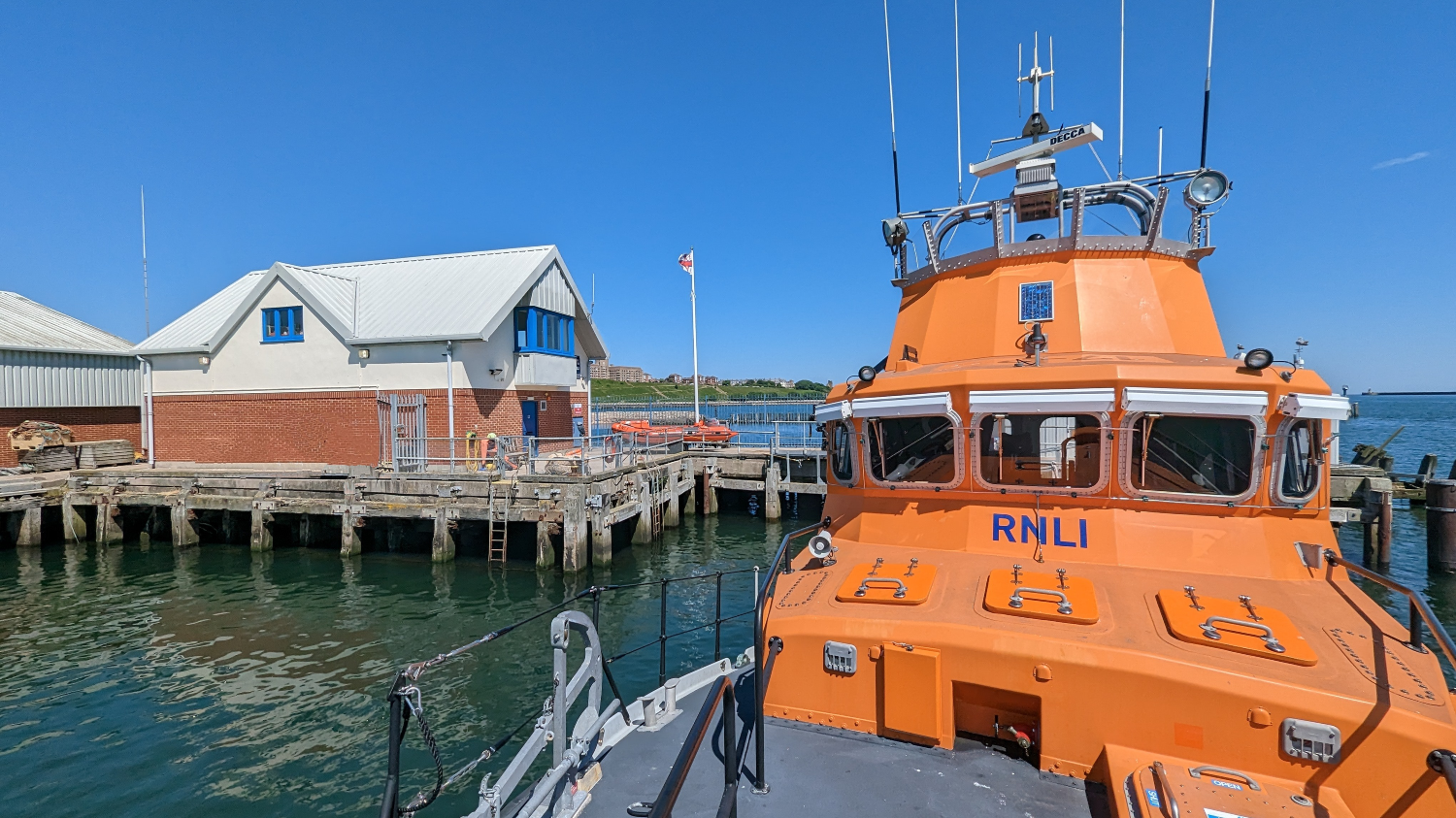 an orange boat is docked at a dock.