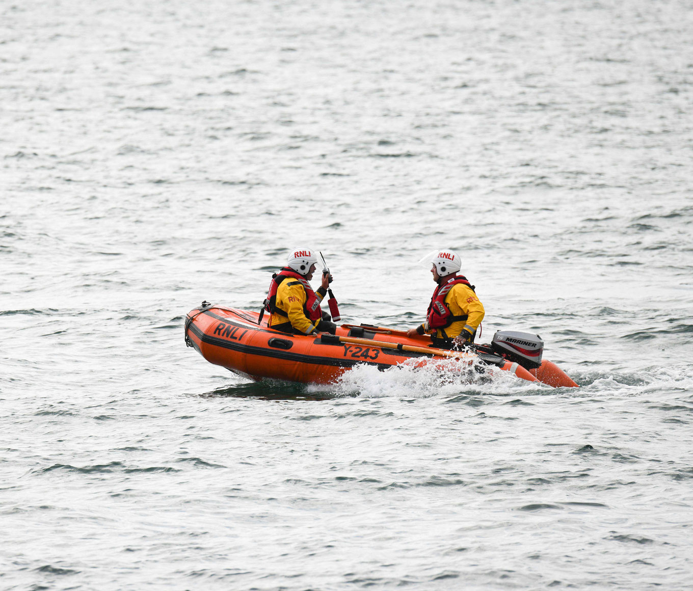 Portpatrick’s Y-class lifeboat floats on calm seas while two crew members conduct a training exercise onboard