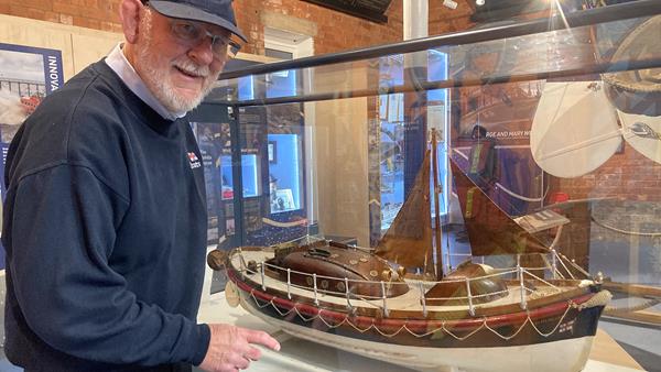 Mike Major, Chairman of Whitby RNLI, inspecting the model of Mary Ann Hepworth, which is in a glass display cabinet. 