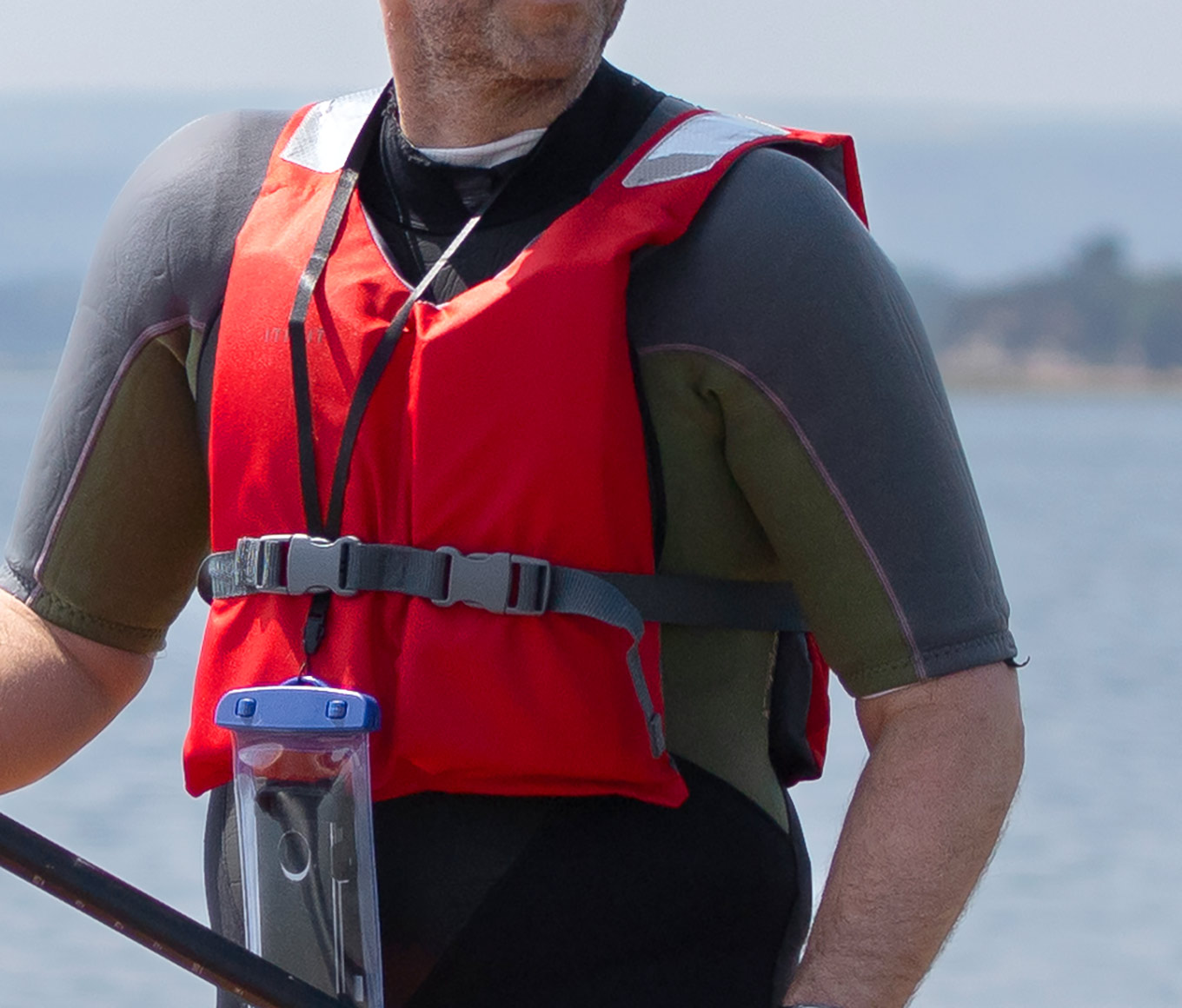 Stand-up paddleboarder wearing a buoyancy aid.