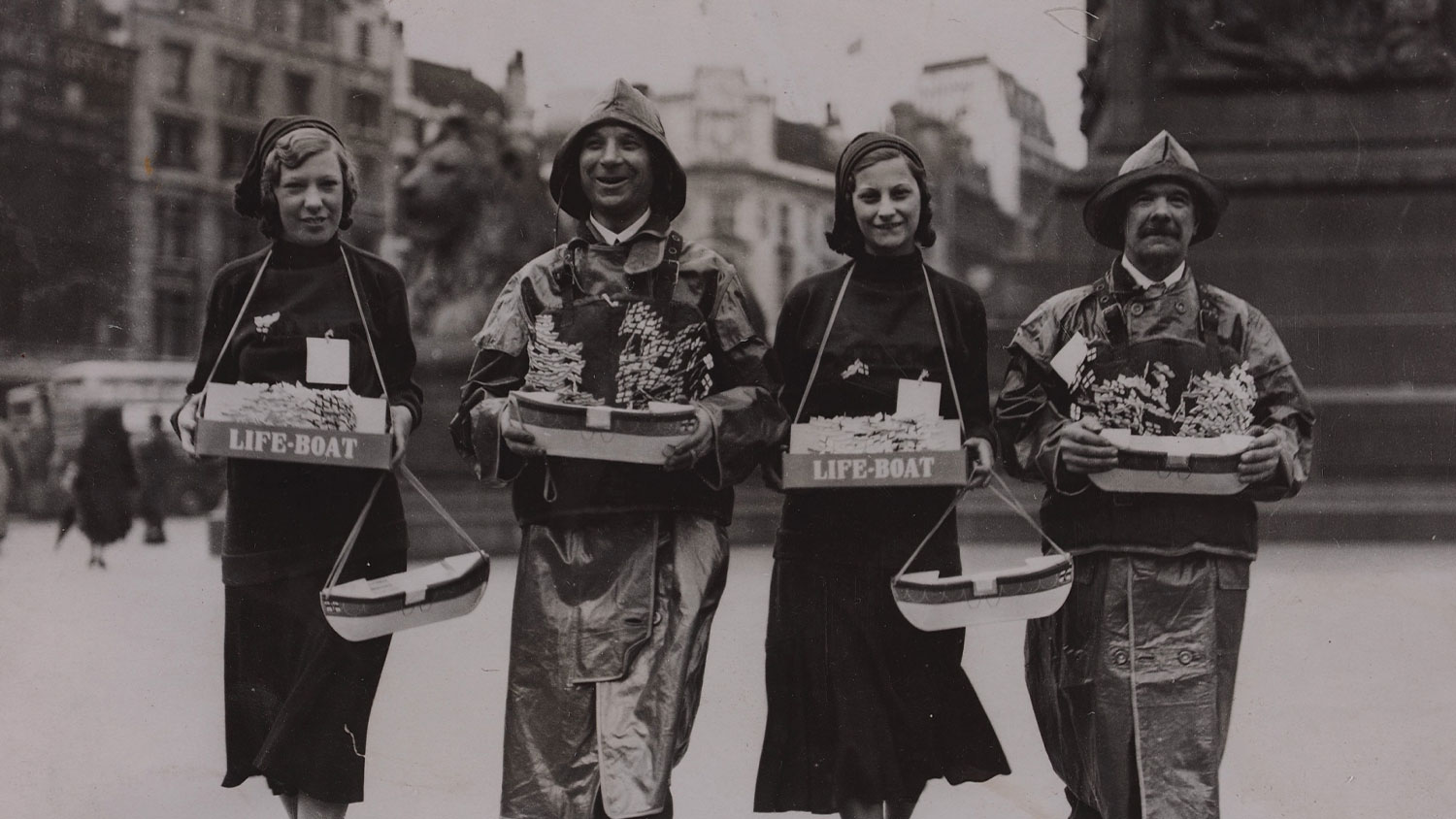 Four RNLI lifesavers stand in Trafalgar Square