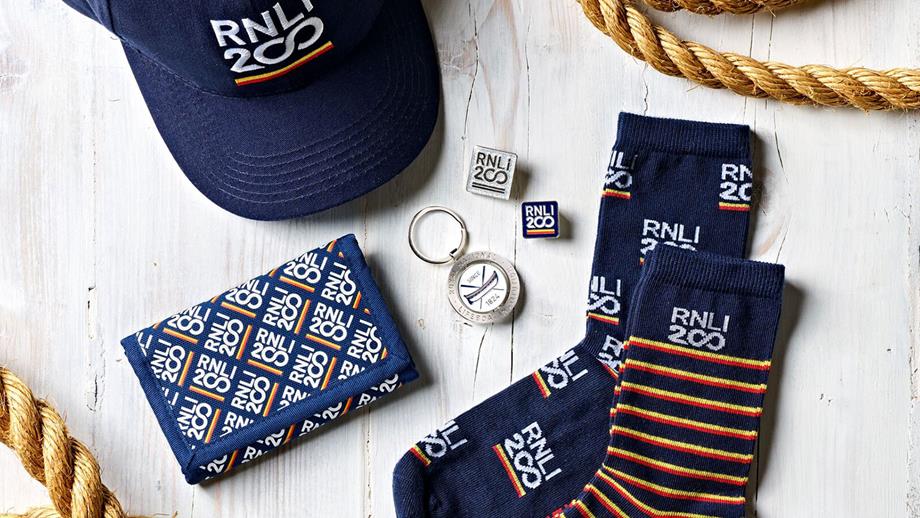Flat lay of shop RNLI 200 products including socks, cap and keyring