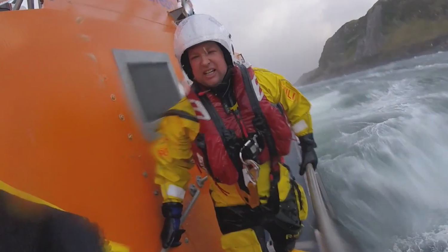 Crew member onboard the lifeboat in rough sea.