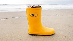 RNLI Welly filled with coins on the beach