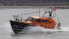 Invergordon lifeboat station's Shannon class lifeboat moving through the water with bunting displayed.
