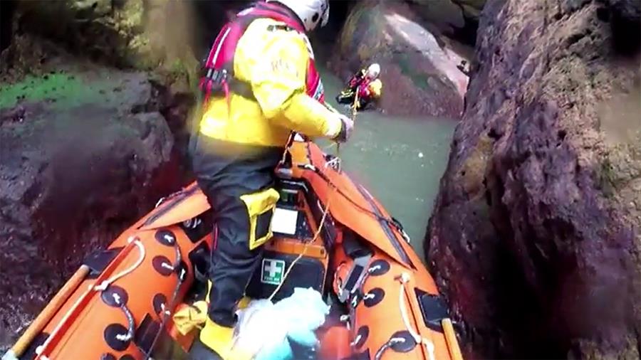 The crew at Arbroath carefully navigate a narrow gully to reach a cocker spaniel who had fallen from the cliffs