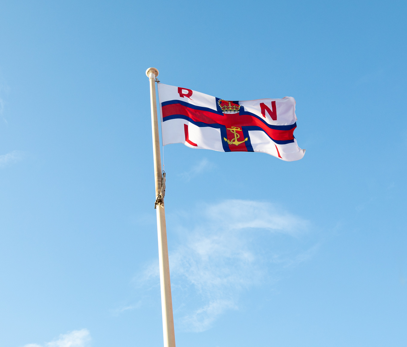 RNLI flag flying on top of flagpole on a clear day