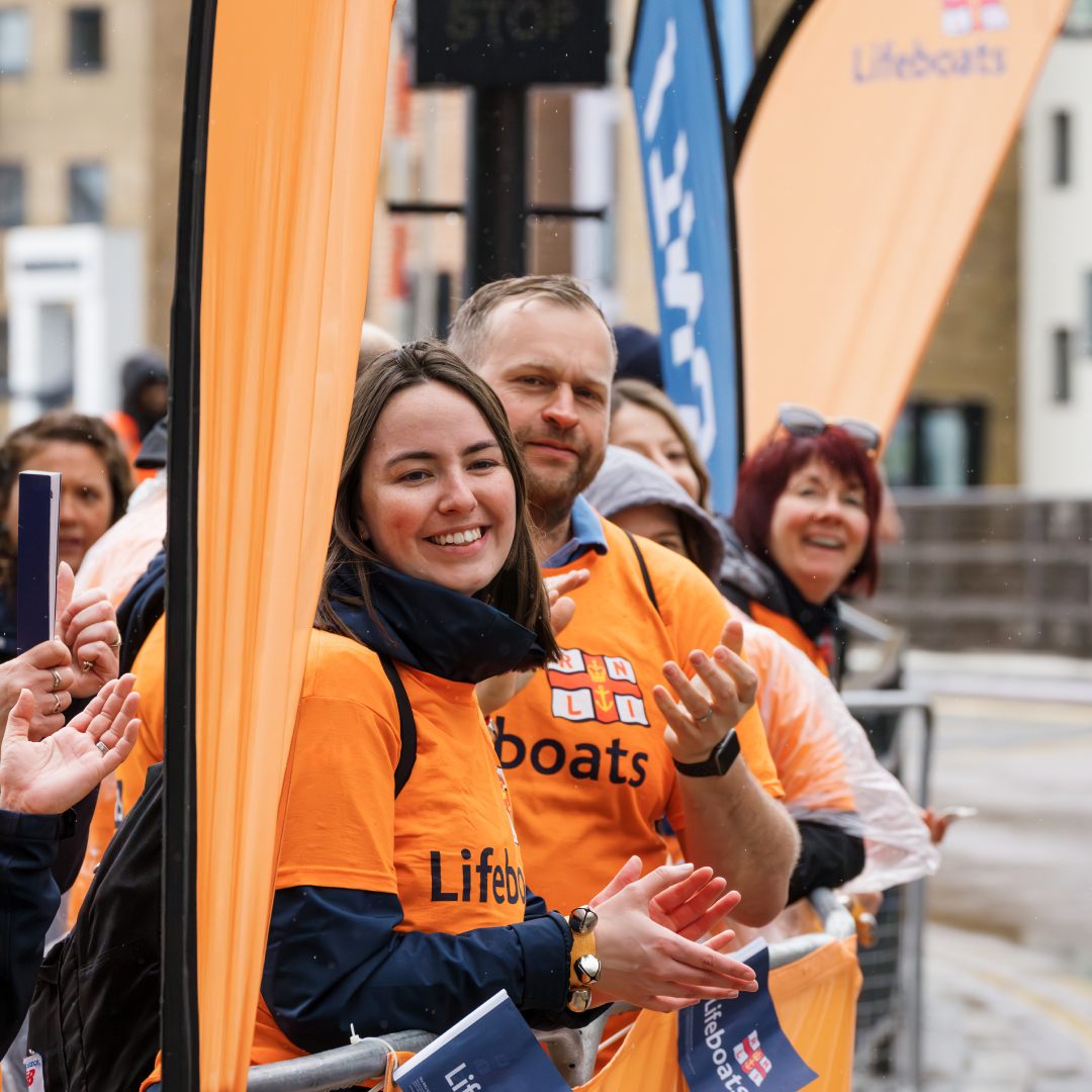 Cheerers stood behind railings supporting the RNLI at the London Marathon