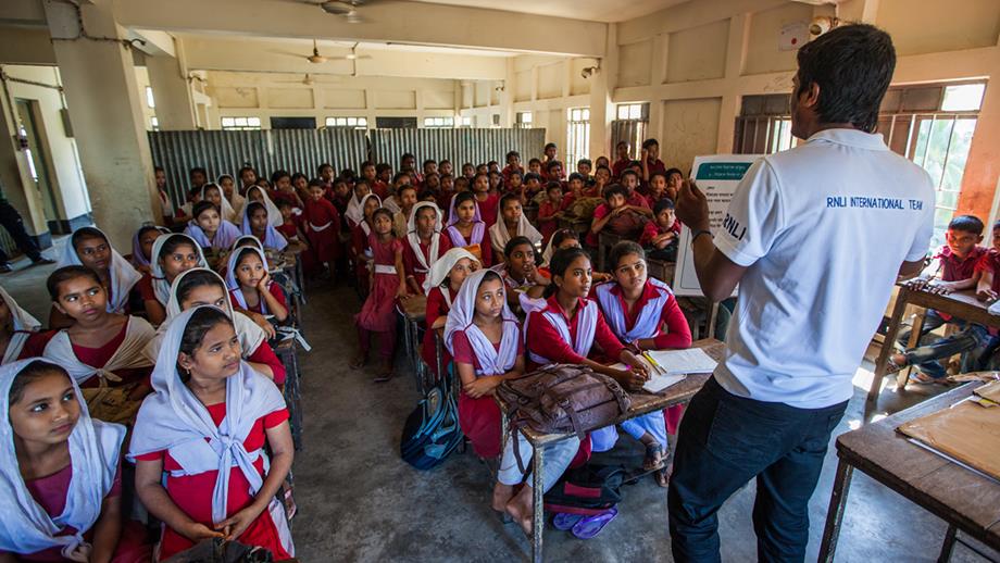 A lifeguard teaching water safety to a class of girls in Bangladesh