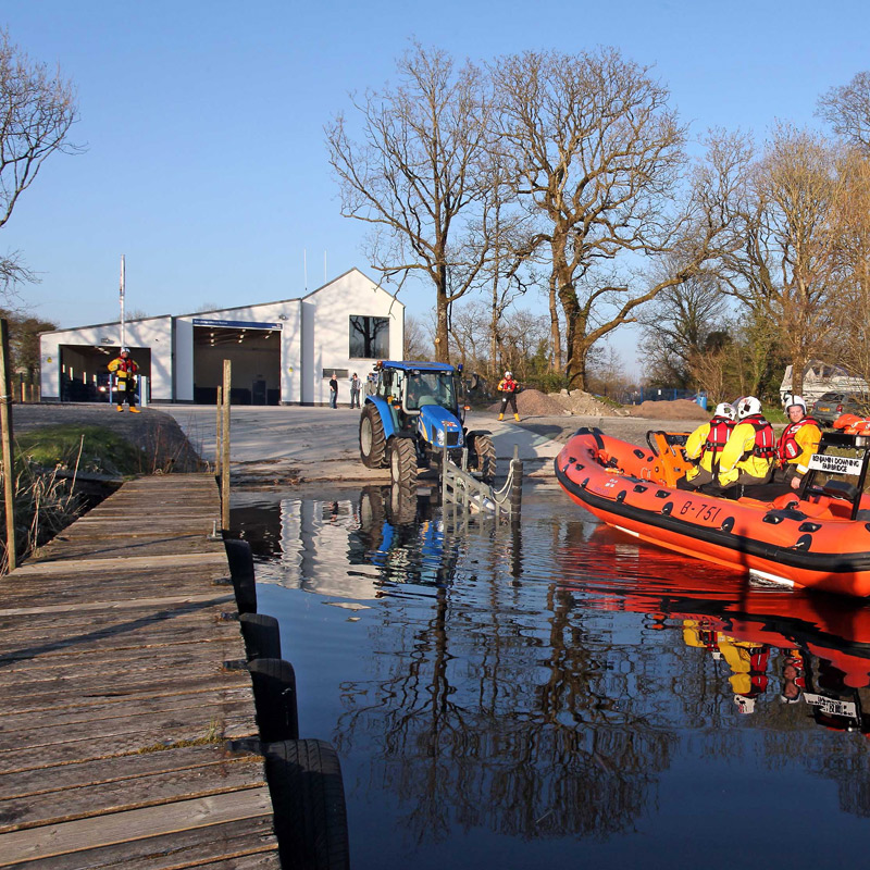 A tractor launches a B class lifeboat into a lough next to the Carrybridge boathouse