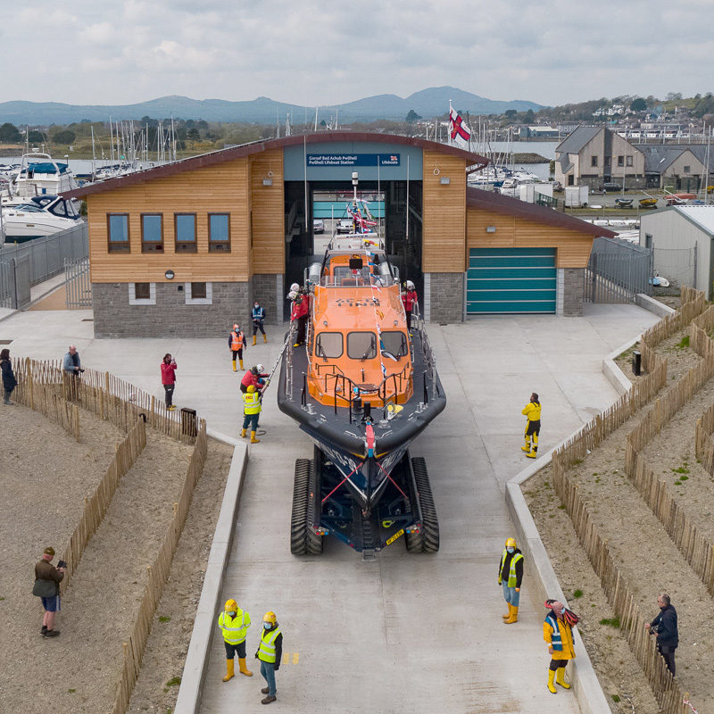 Drone shot of Pwllheli lifeboat station with a Shannon class lifeboat moving down the slipway