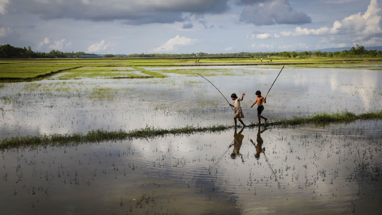 Reflections, brother and sister, Reshma (8) and Ridoy (9) are fishing on floodwaters in Cox’s Bazaar, Bangladesh after a monsoon.